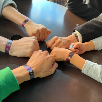 a group of people reaching their hands in to celebrate